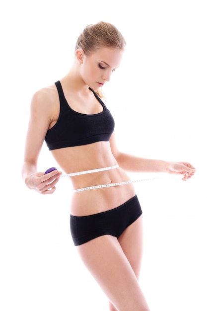 Beautiful woman measuring her waistline