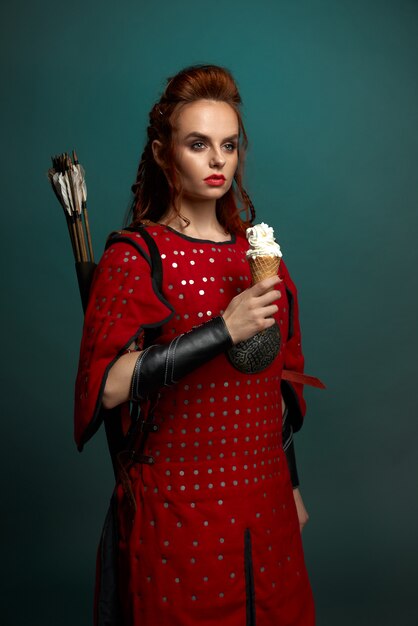 アイスクリームを保持している中世の衣装で美しい女性。