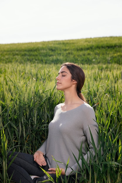 Free photo beautiful woman meditating in nature