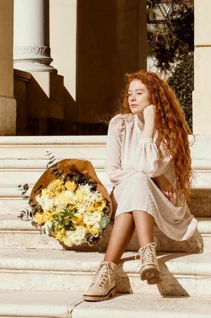 春の花の花束を持つ屋外の美しい女性