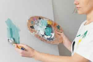 Foto gratuita bella donna che dipinge con acrilici su tela