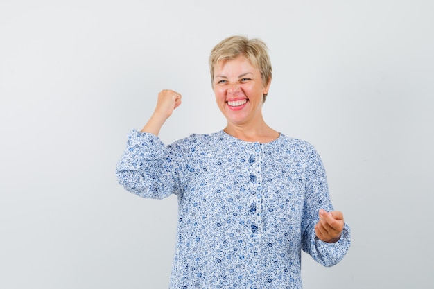 Beautiful woman in patterned blouse showing her happiness , front view.