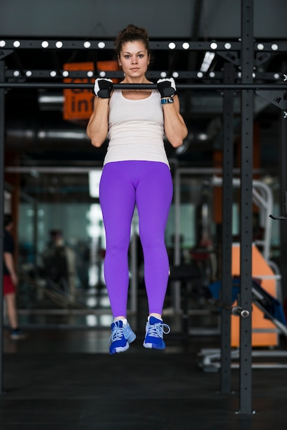 Beautiful woman performing pull-ups