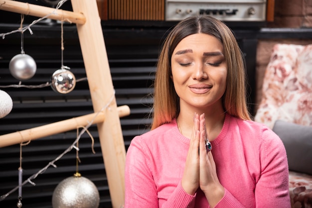 Beautiful woman in pink sweater doing meditation.