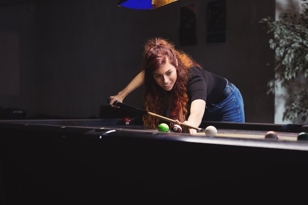 Free photo beautiful woman playing pool