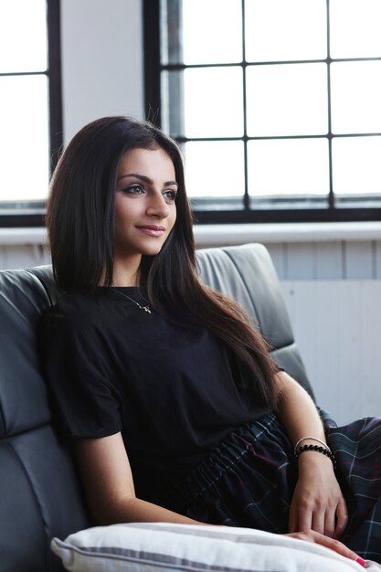 Beautiful woman posing in black sofa