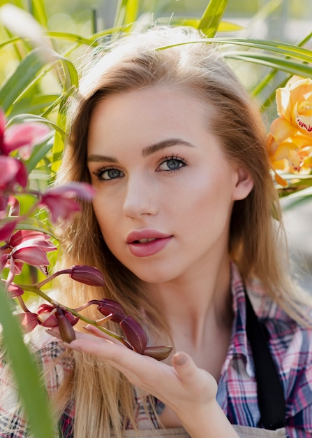 Beautiful woman posing between flowers
