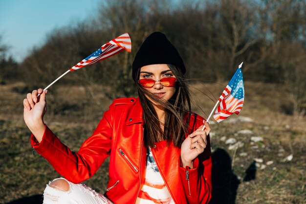 Beautiful woman posing and holding American flags