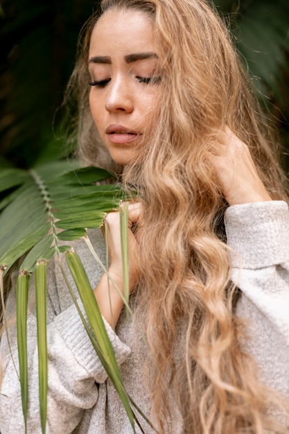 Beautiful woman posing next to leaves