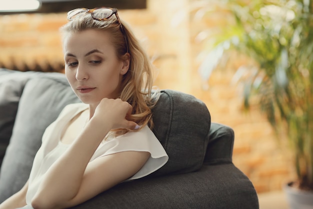 Free photo beautiful woman posing in the sofa, interior home