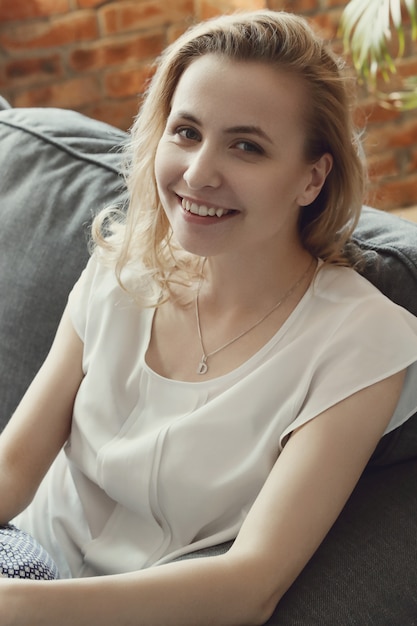 Beautiful woman posing in the sofa, interior home