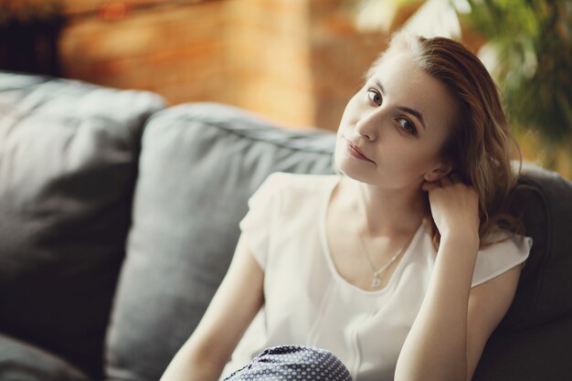 Beautiful woman posing in the sofa, interior home