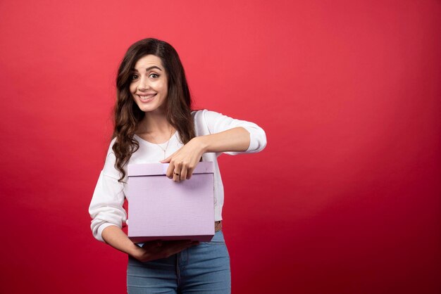 Beautiful woman posing with purple present box. High quality photo