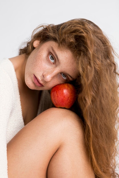 Bella donna che posa con la mela rossa