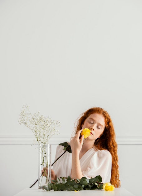 Foto gratuita bella donna in posa con fiori primaverili e vaso con copia spazio