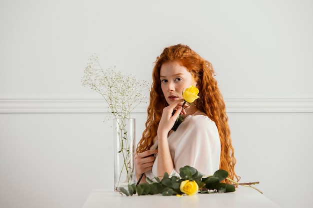 Bella donna in posa con fiori primaverili e vaso