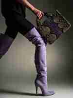 Free photo beautiful woman in purple high boots. fashionable girl holds stylish violet leather bag. glamour stylish concept. art. model walks after shopping.