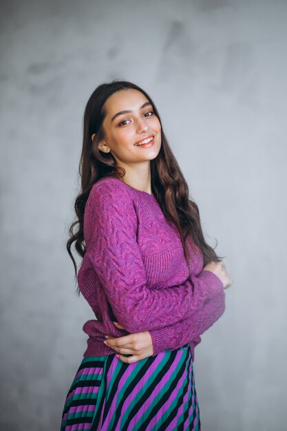 Beautiful woman in a purple sweater and skirt