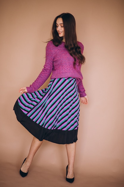 Beautiful woman in a purple sweater and skirt