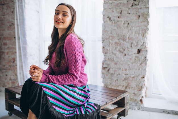 Beautiful woman in a purple sweater and skirt