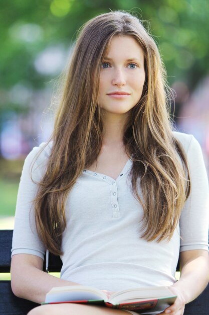 Beautiful woman reading book in the park