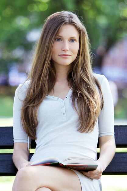 Beautiful woman reading book in the park