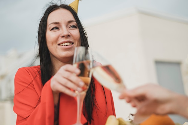 Bella donna in abito rosso rallegrare un bicchiere di champagne