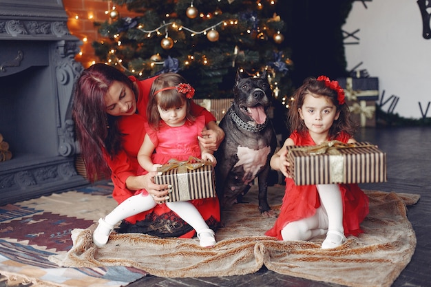 Bella donna in un vestito rosso. famiglia a casa. madre con figlia. persone con un cane.