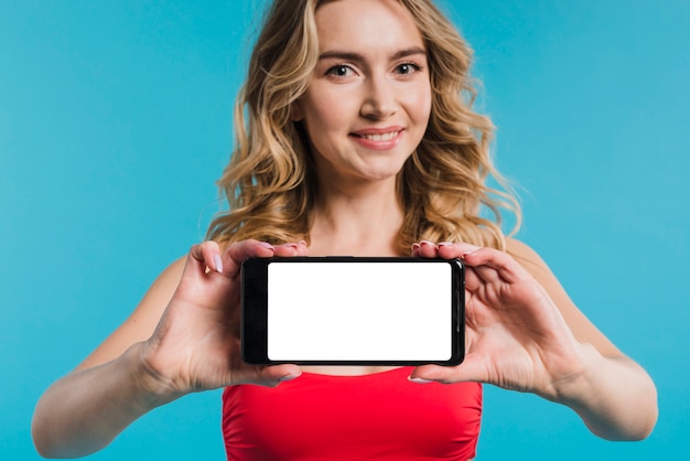 Beautiful woman in red top showing mobile phone