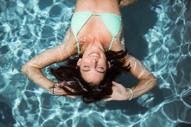 Foto gratuita bella donna che si distende in piscina