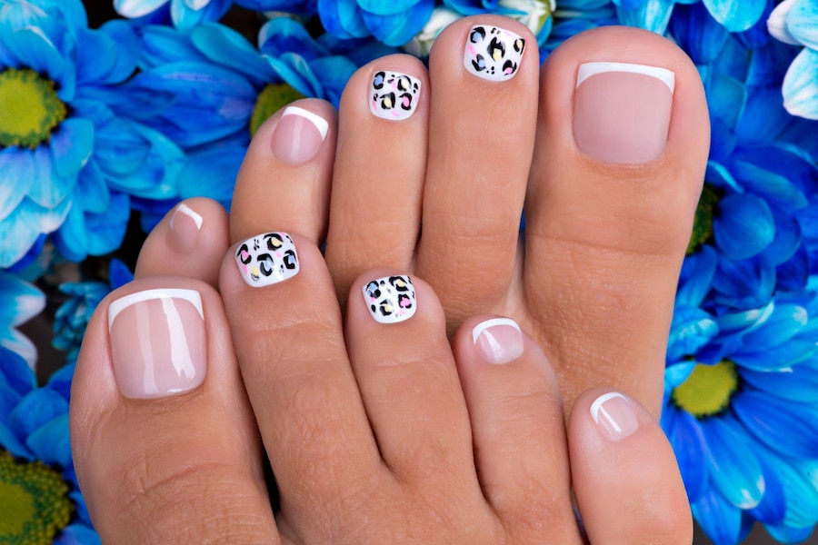 Beautiful woman's nails of legs with beautiful french manicure and art design