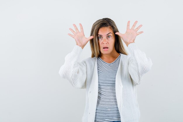 Beautiful woman showing ten fingers in jacket and looking awake. front view.