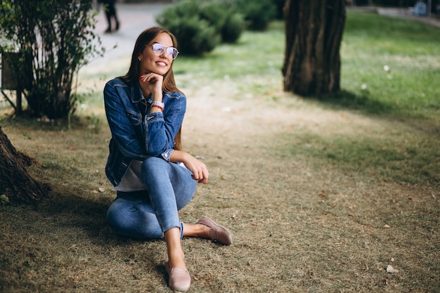 Free photo beautiful woman sitting ander a tree