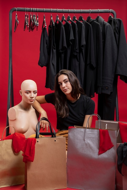 beautiful woman sitting next to mannequin