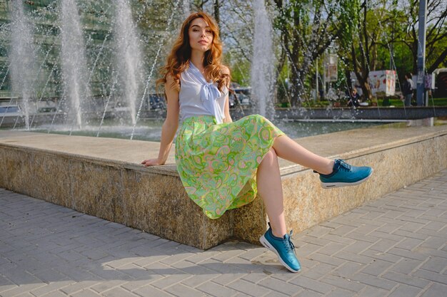 Beautiful woman sitting near fountain