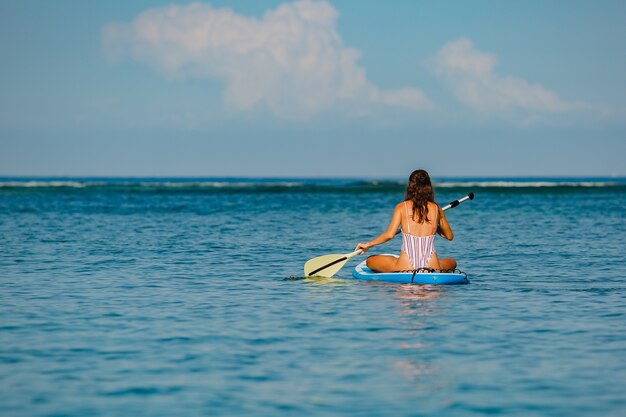 Beautiful woman sitting on sup. 