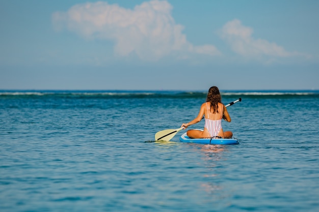 Beautiful woman sitting on sup. 