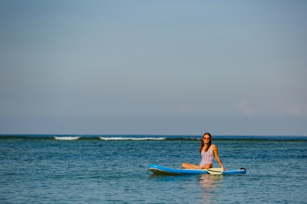 Beautiful woman sitting on sup. 