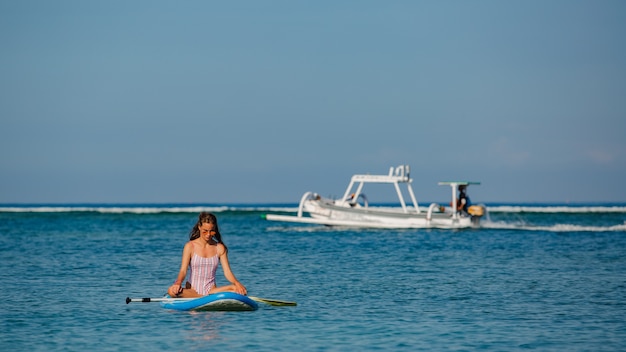 Beautiful woman sitting on sup. 