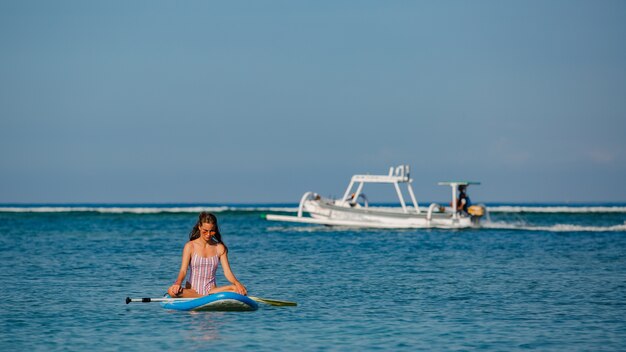 Beautiful woman sitting on sup. 