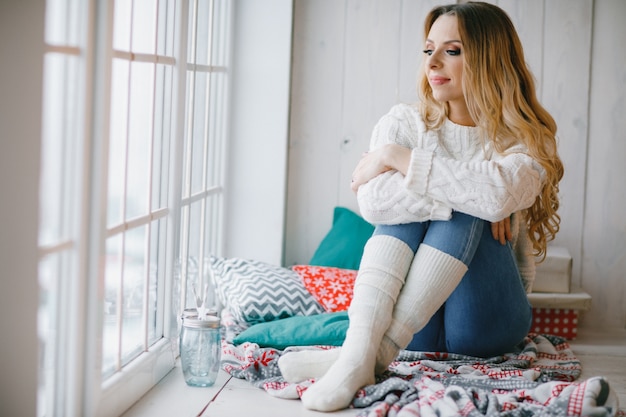 beautiful woman sitting on the window still