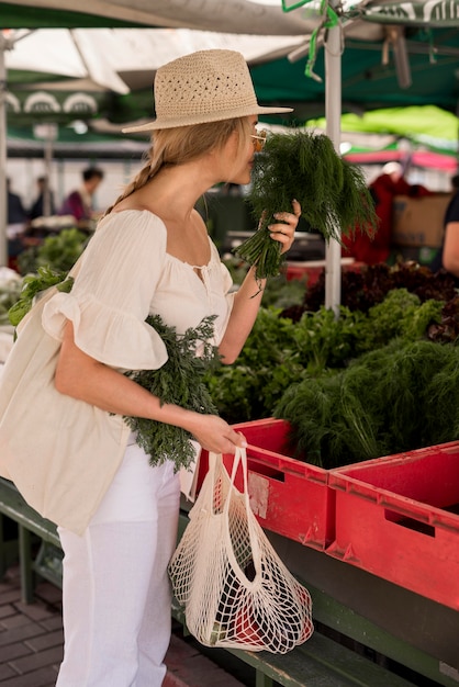 Beautiful woman smelling dill leaves