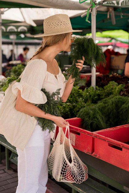 Beautiful woman smelling dill leaves