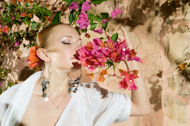 Beautiful woman smelling flowers
