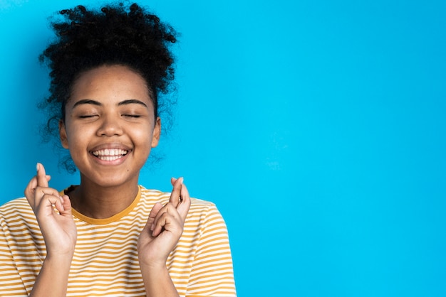 Free photo beautiful woman smiling and posing with fingers crossed