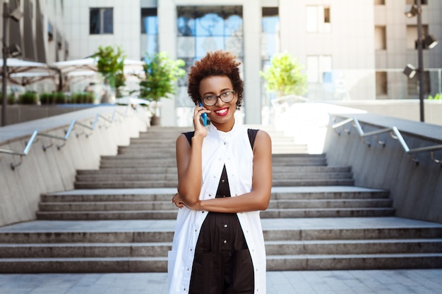 Beautiful woman smiling speaking on phone walking down city