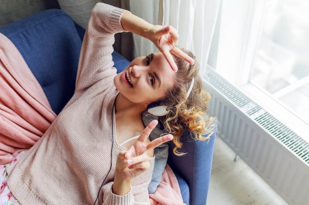 Foto gratuita bella donna sul divano ascoltando musica