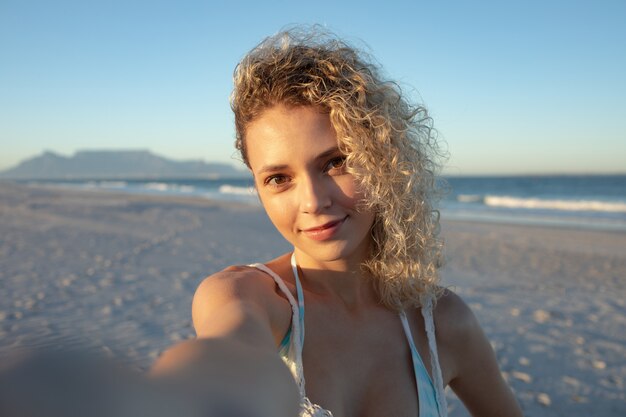 Красивая женщина, стоящая на пляже