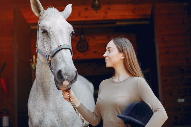 Красивая женщина, стоящая с лошадью