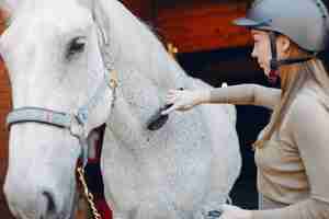 Foto gratuita bella donna in piedi con un cavallo